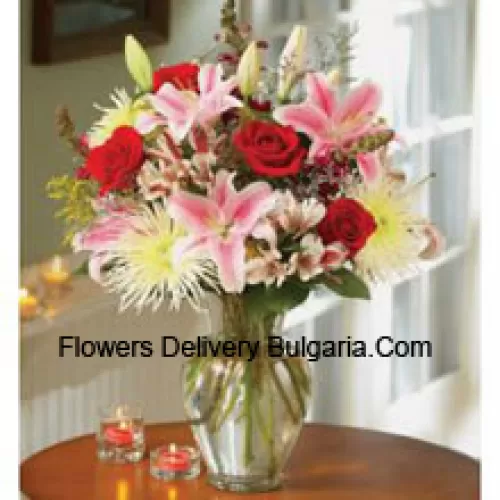 Lys roses et roses rouges dans un vase en verre