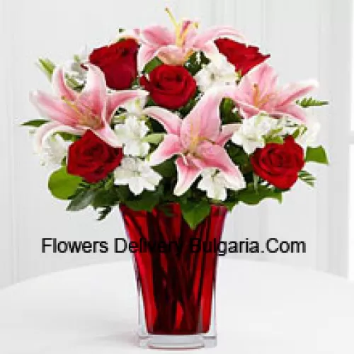 6 roses rouges et 5 lis roses avec des remplisseurs saisonniers dans un beau vase en verre