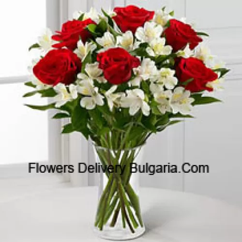 7 Roses rouges avec des fleurs blanches assorties et des remplisseurs dans un vase en verre