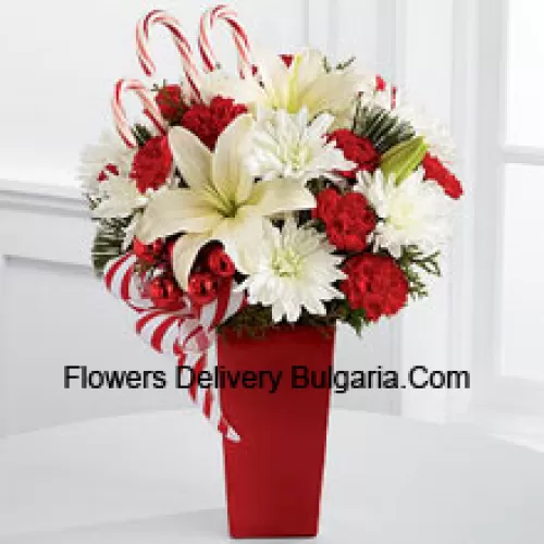 Bursts with the bright cheer and jubilant beauty of this special season. White Asiatic Lilies and chrysanthemums sit amongst red mini carnations, assorted holiday greens, red glass balls, three candy canes and festive ribbon, perfectly arranged in a red ceramic vase to create a lively bouquet of merry wishes for a splendid holiday season! (Please Note That We Reserve The Right To Substitute Any Product With A Suitable Product Of Equal Value In Case Of Non-Availability Of A Certain Product)
